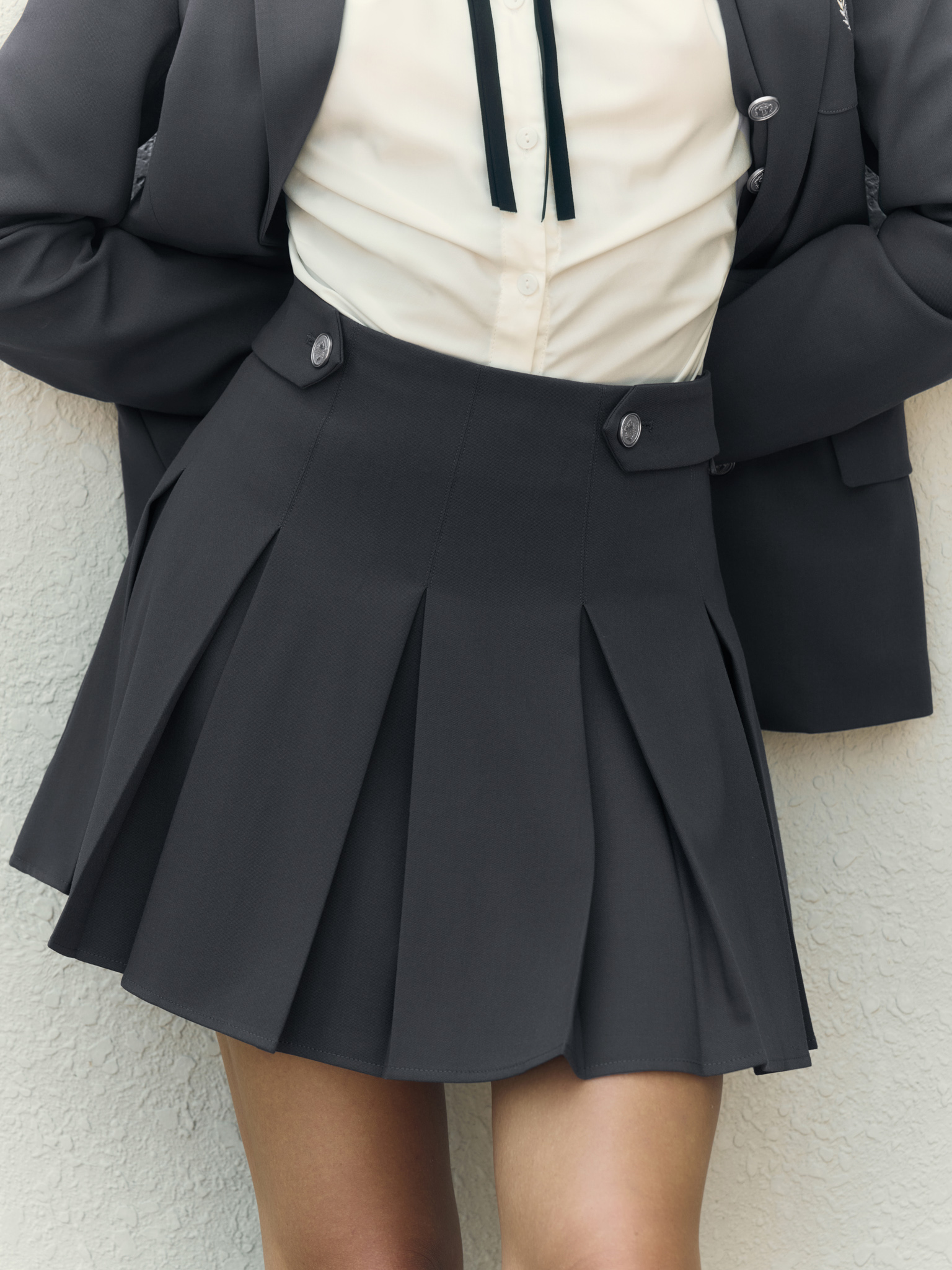 Mini pleated skirt with metal buttons on the waistband