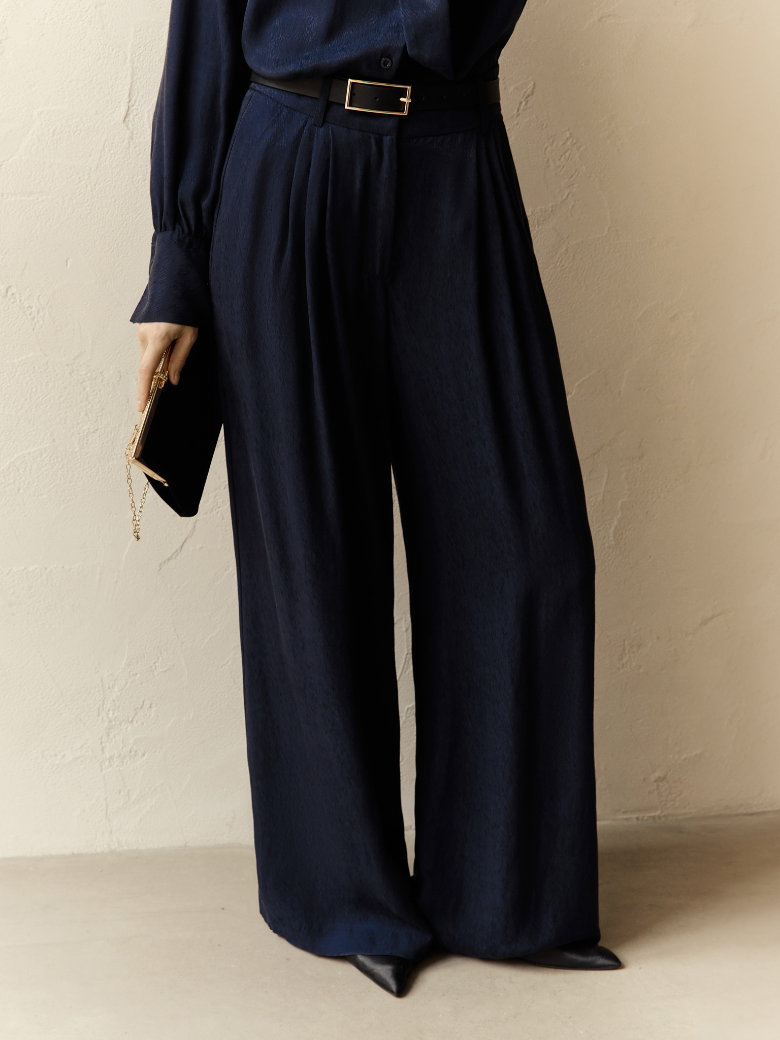 Loose-fitting trousers with waist pleats