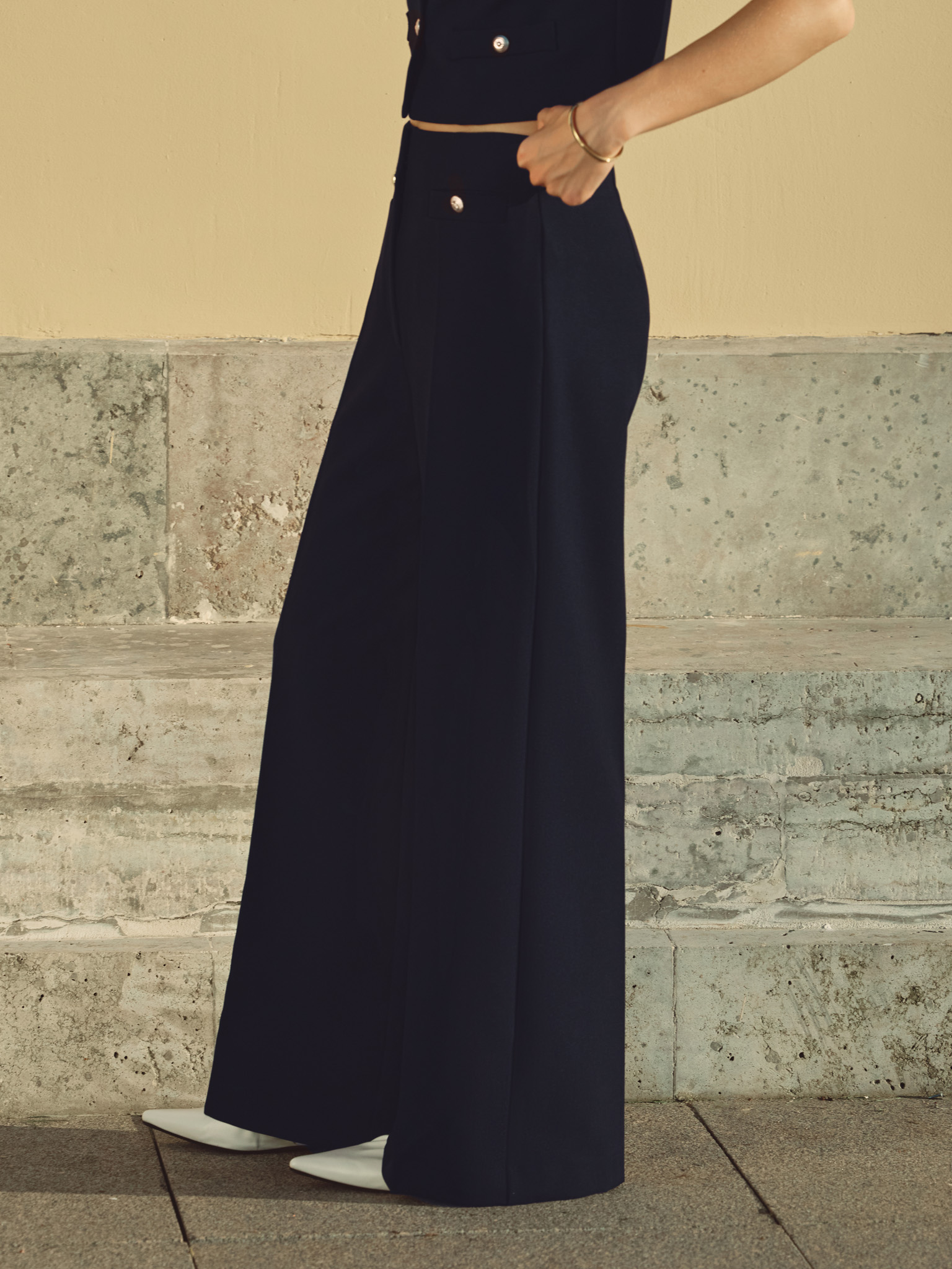 Mid-rise trousers with front creases and oversized buttons