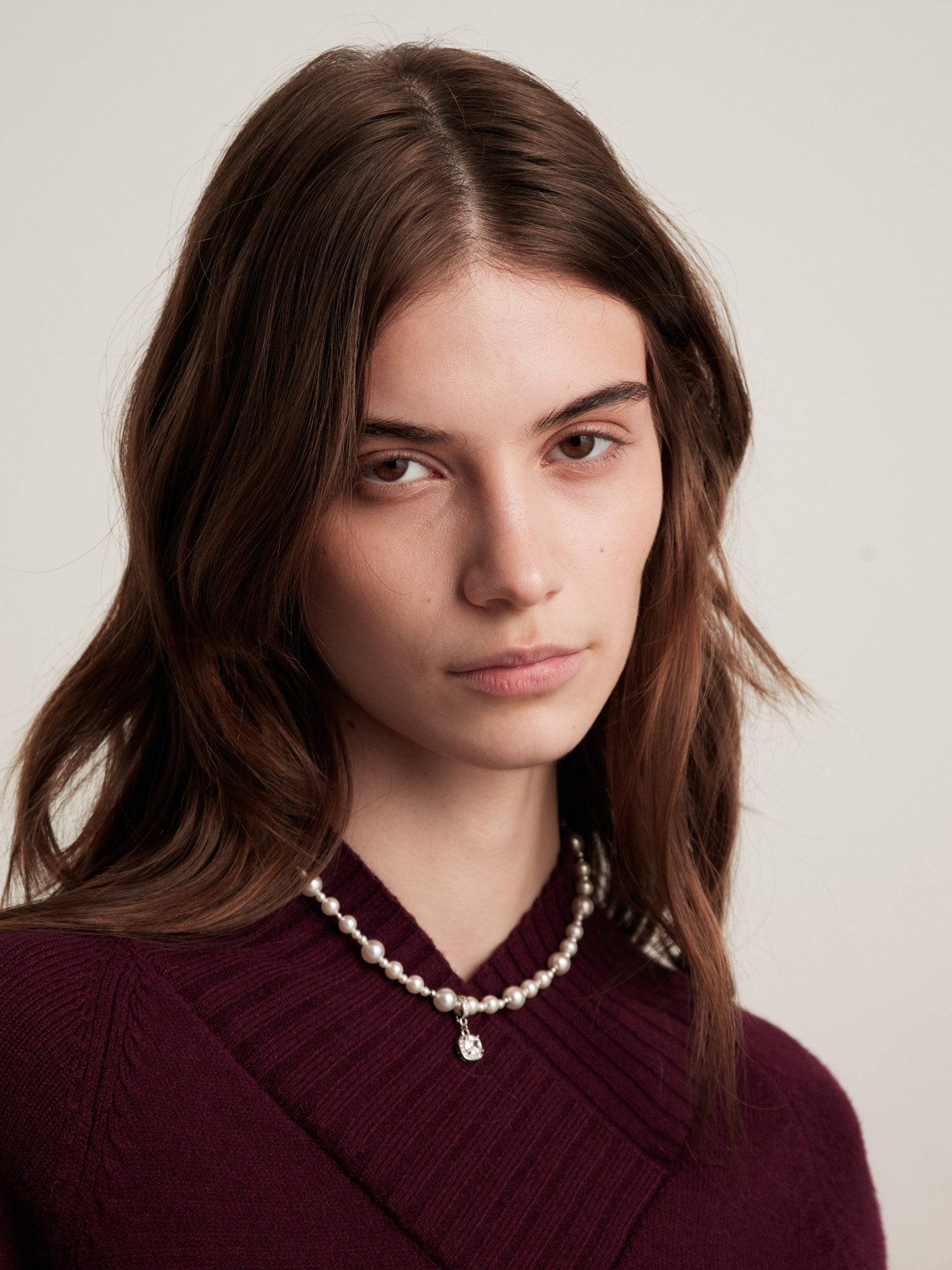 Necklace made of different sized beads with a rhinestone pendant