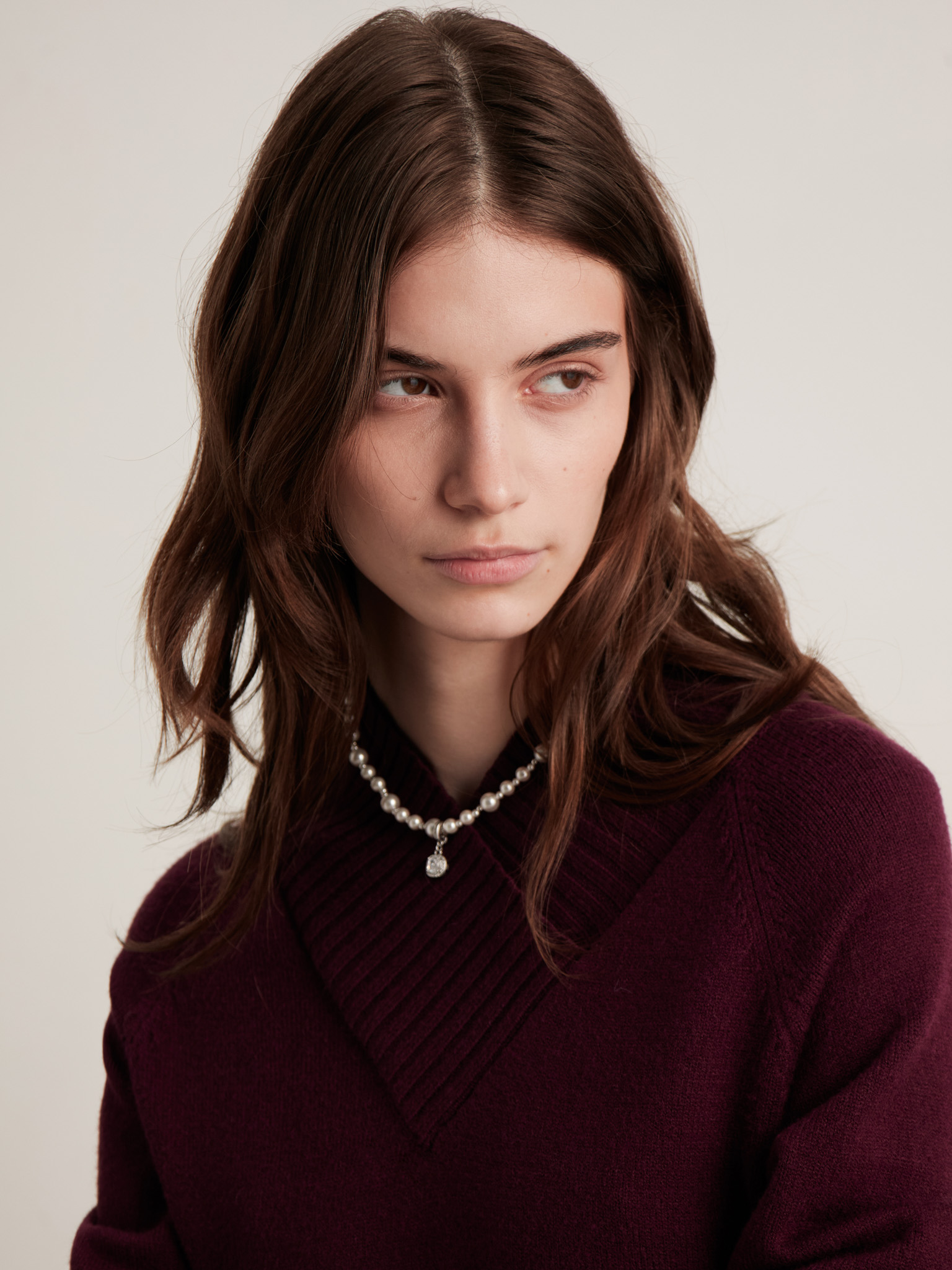 Necklace made of different sized beads with a rhinestone pendant