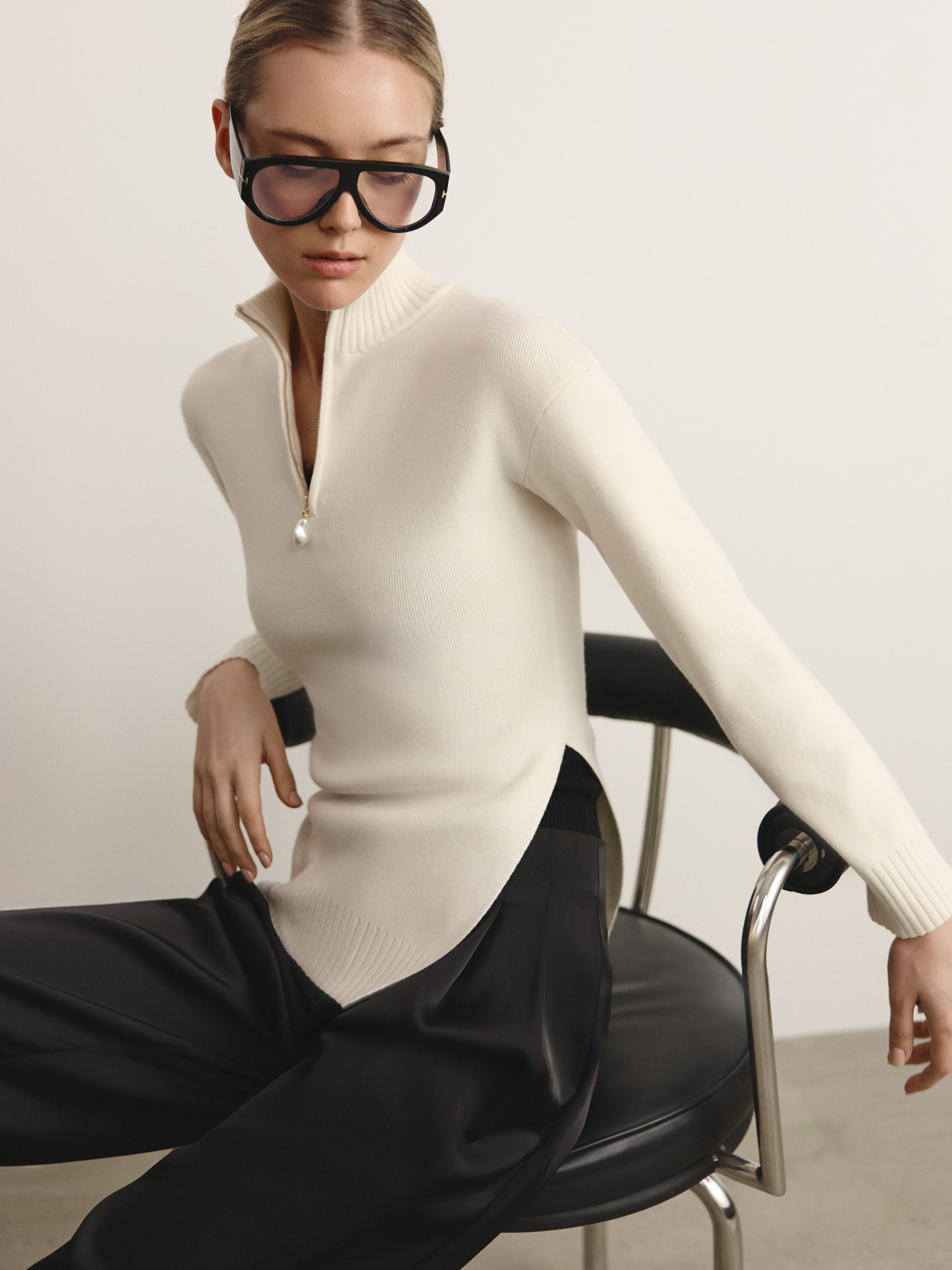 Knitted jumper with zip fastening at the collar and asymmetrical hem