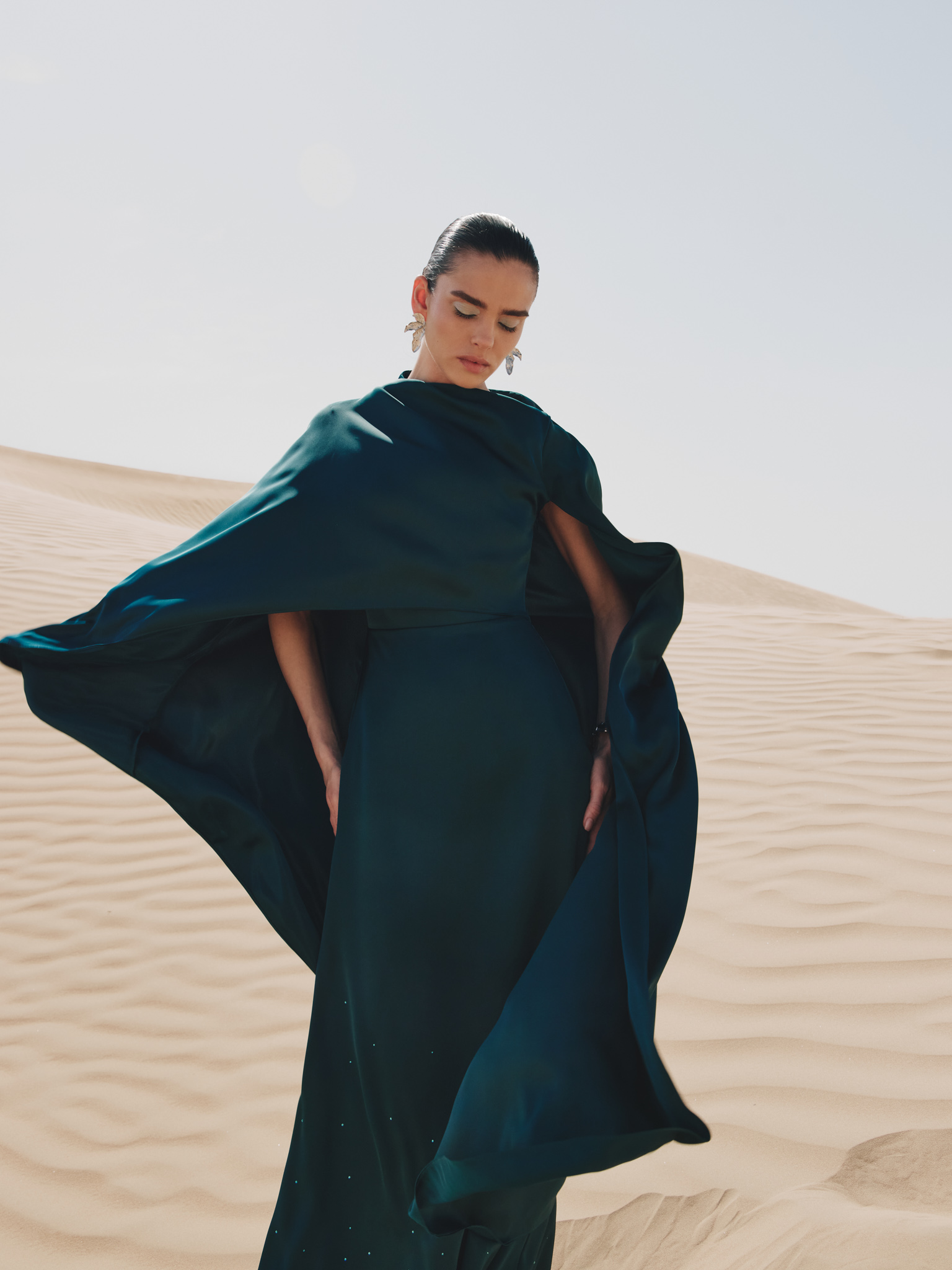 Maxi dress with asymmetrical cape and rhinestones on the skirt