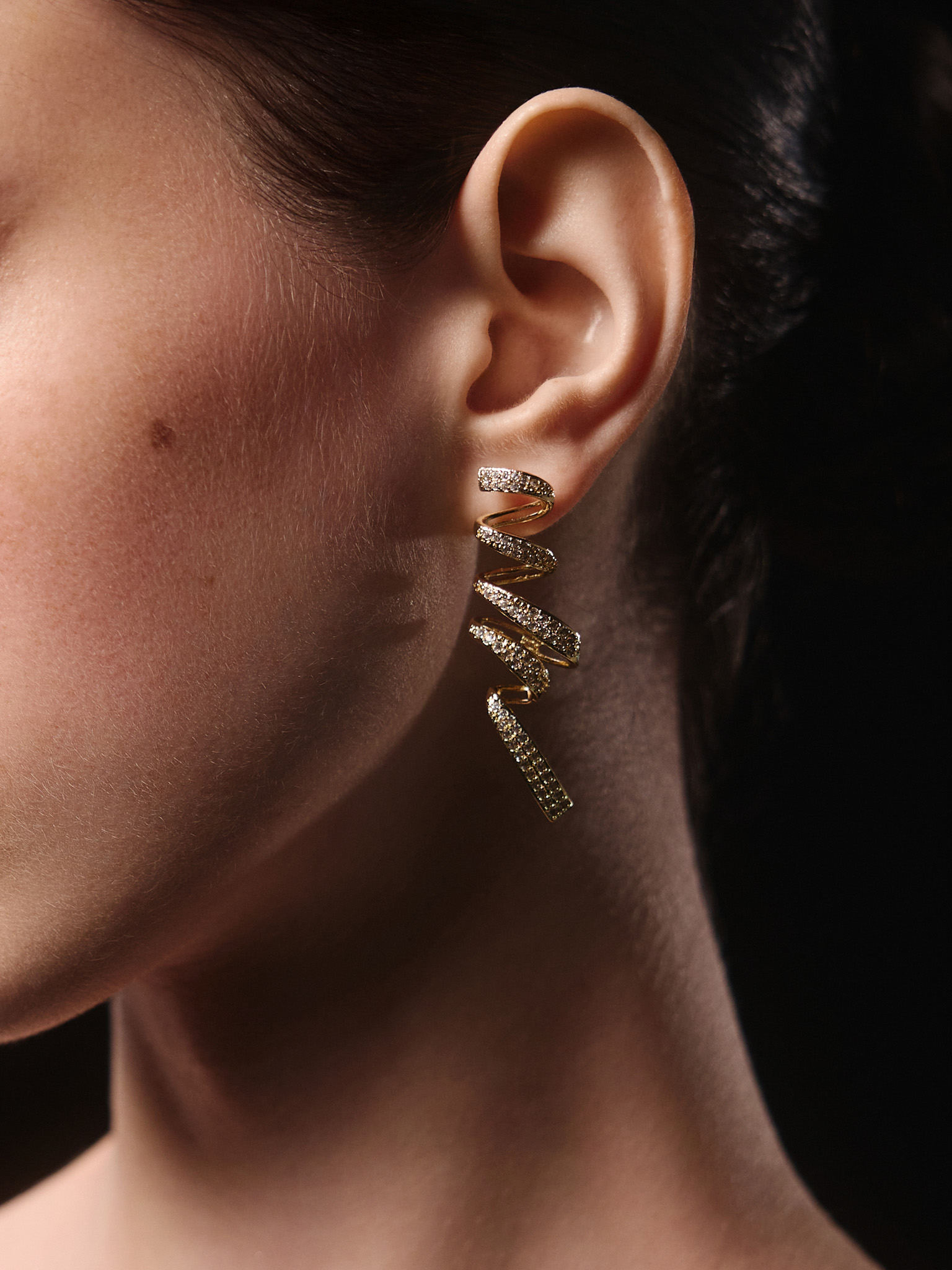 Stud earrings in the form of rhinestone spirals