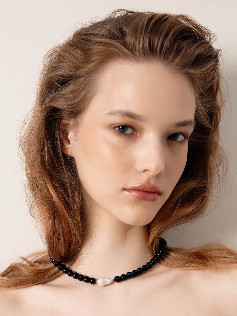 Necklace of bright beads with a pearl in the centre