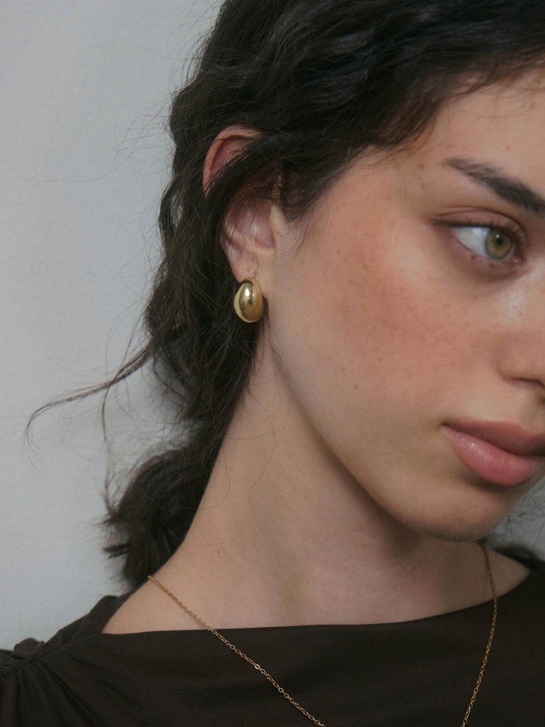 Oval-shaped stud earrings in glossy metal