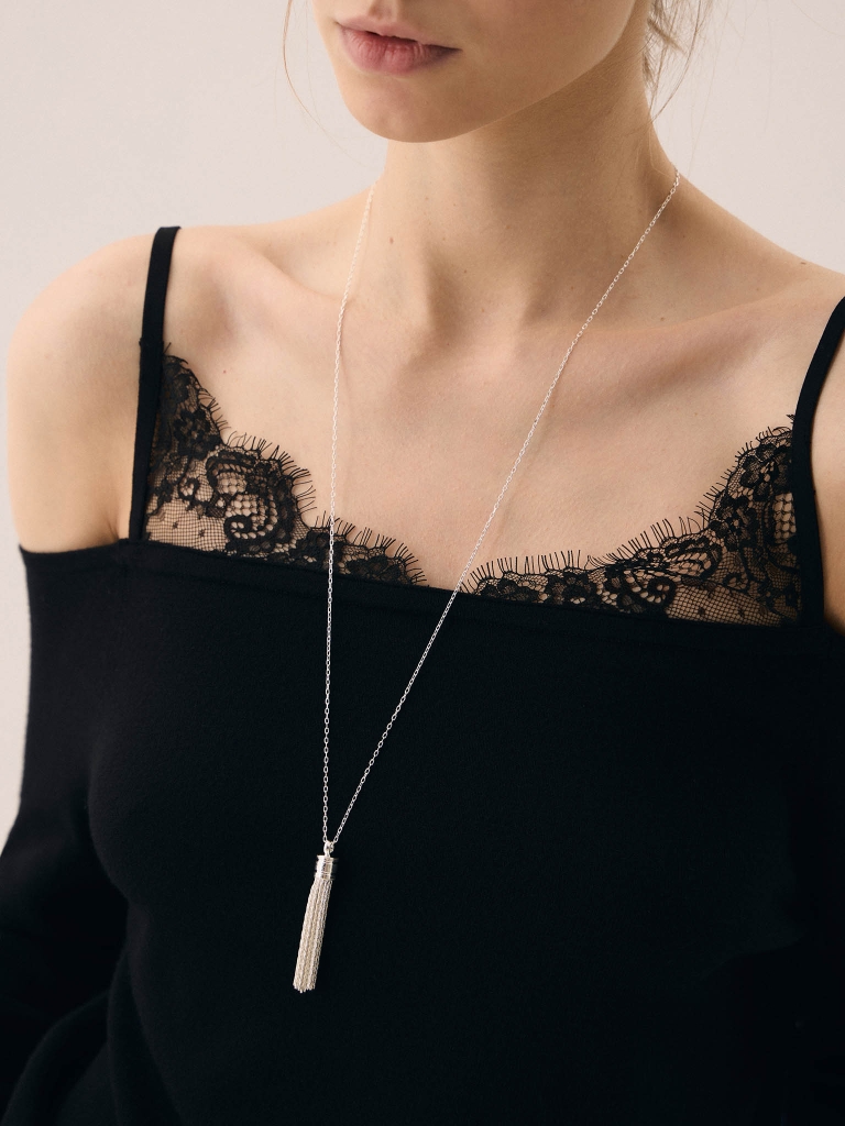 Lange Kette mit einem Anhänger in Form eines Pinsels
