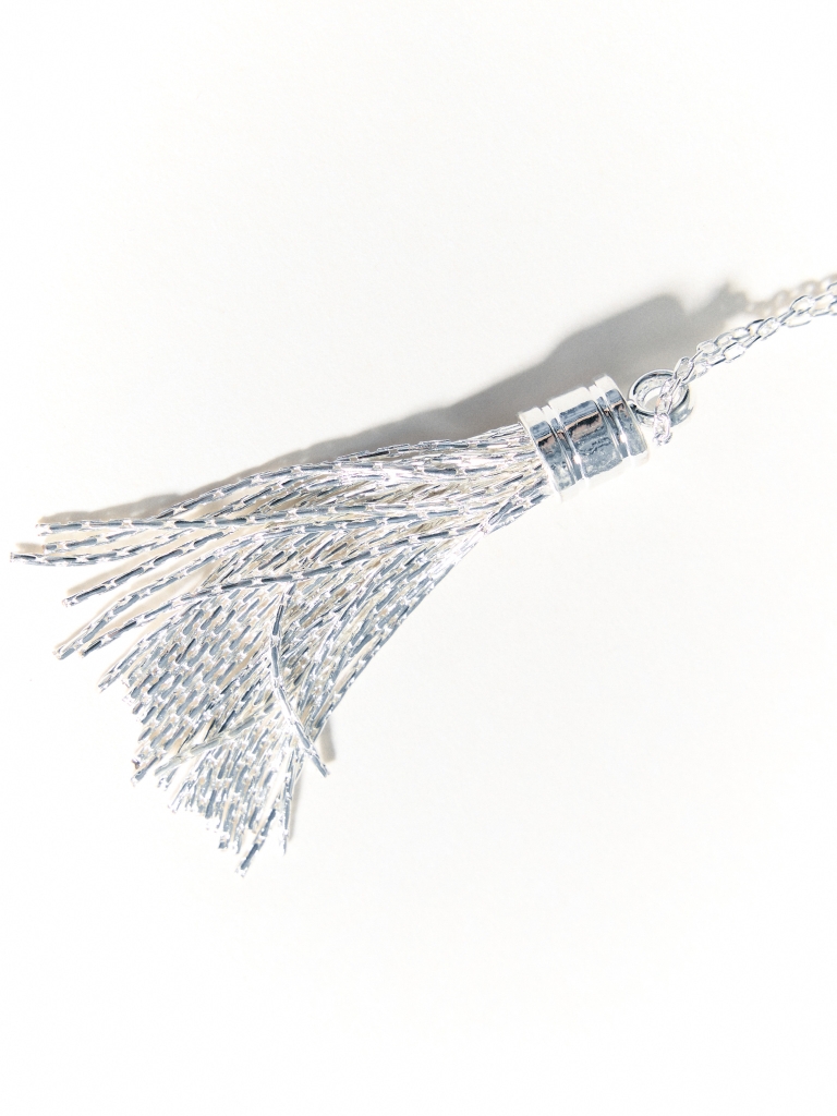 Lange Kette mit einem Anhänger in Form eines Pinsels