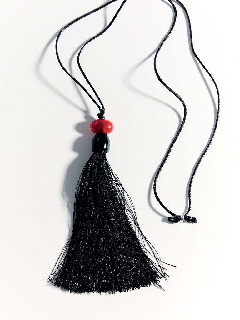 Cord necklace with a bright stone and a tassel pendant
