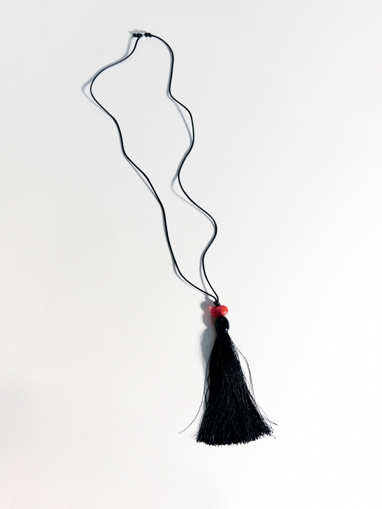 Cord necklace with a bright stone and a tassel pendant