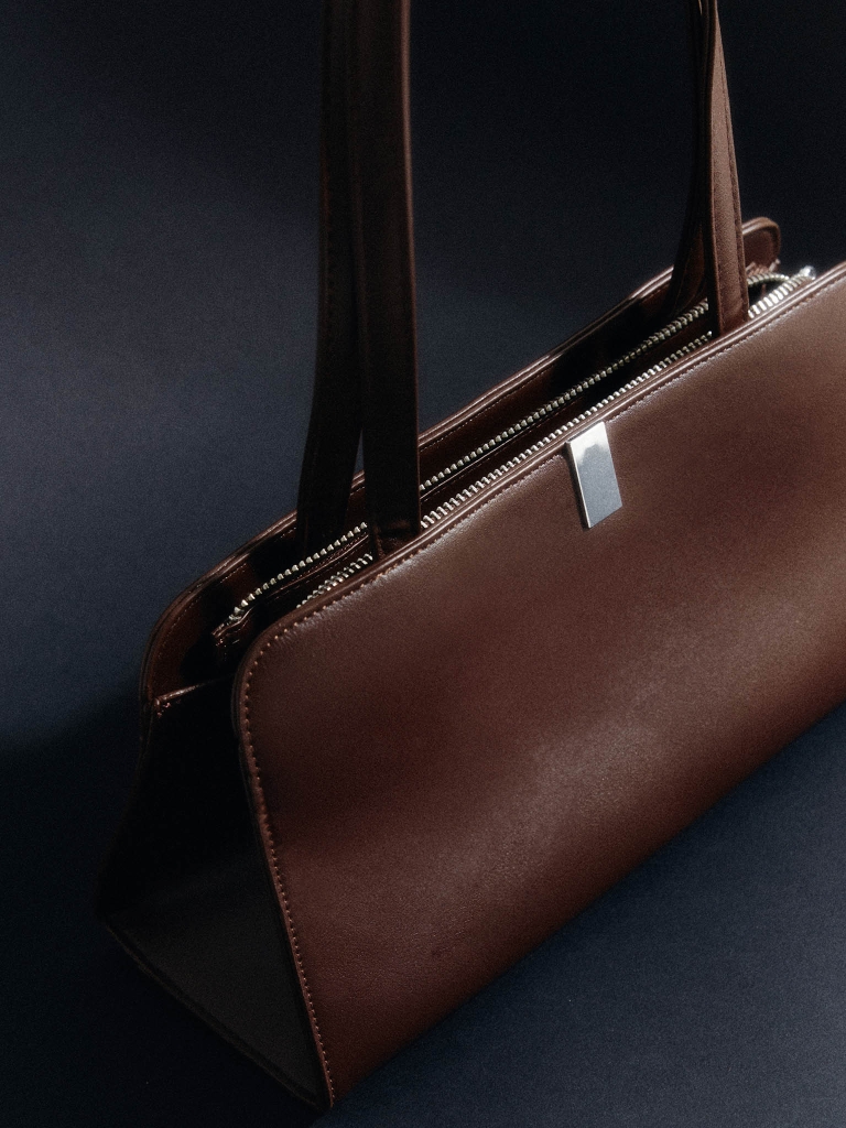 Trapezoid-shaped bag in matte eco-leather with silver accents