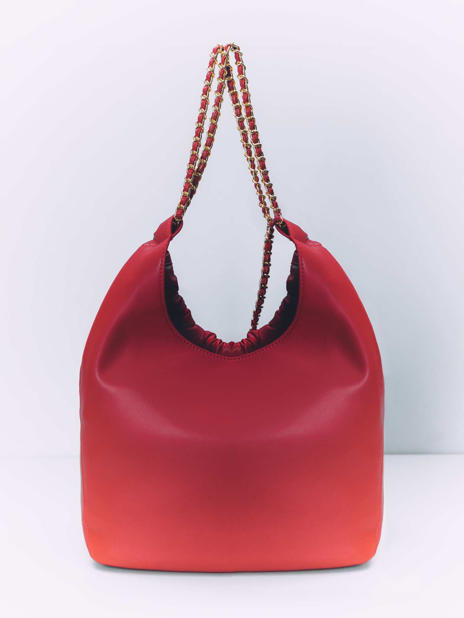 Soft-shaped bag with chain decor on the handles