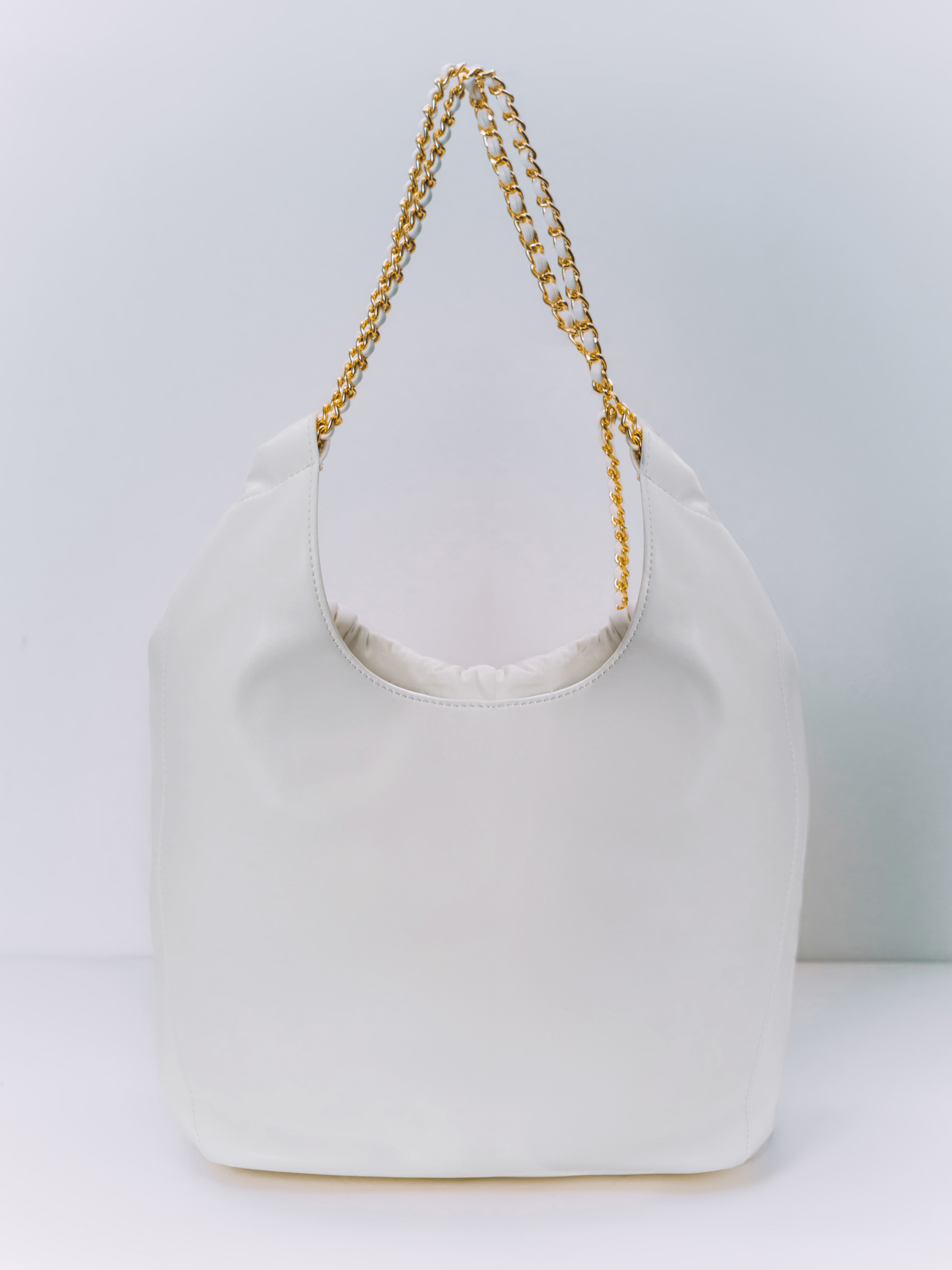 Soft-shaped bag with chain decor on the handles