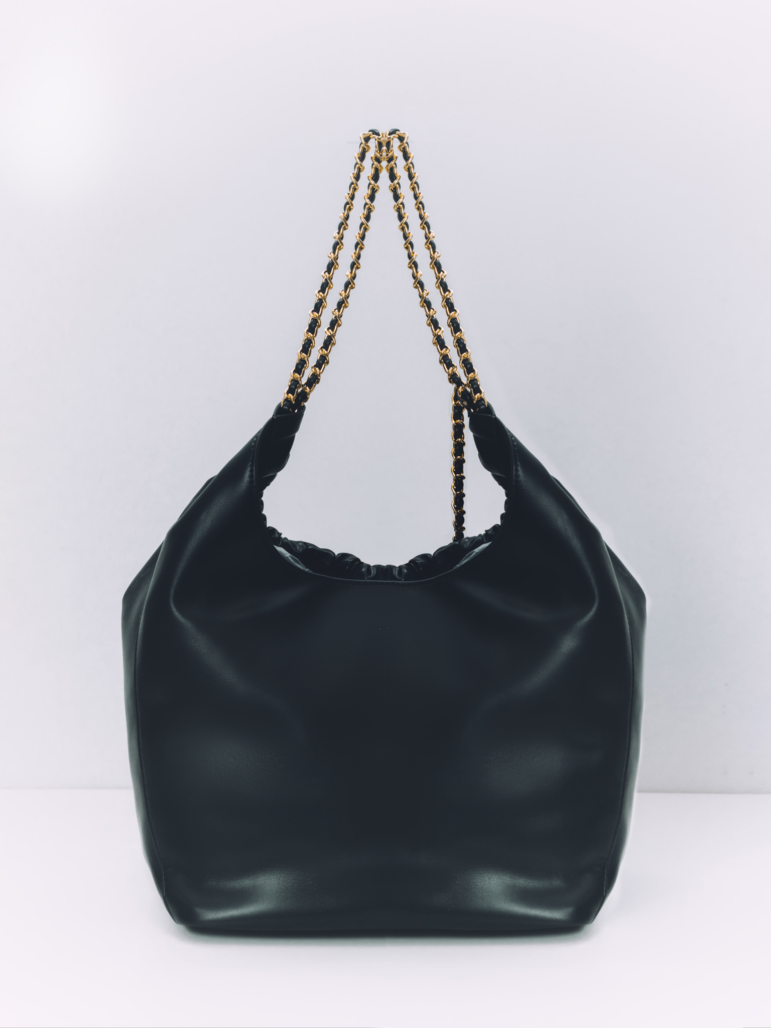 Soft-shaped bag with chain decor on the handles