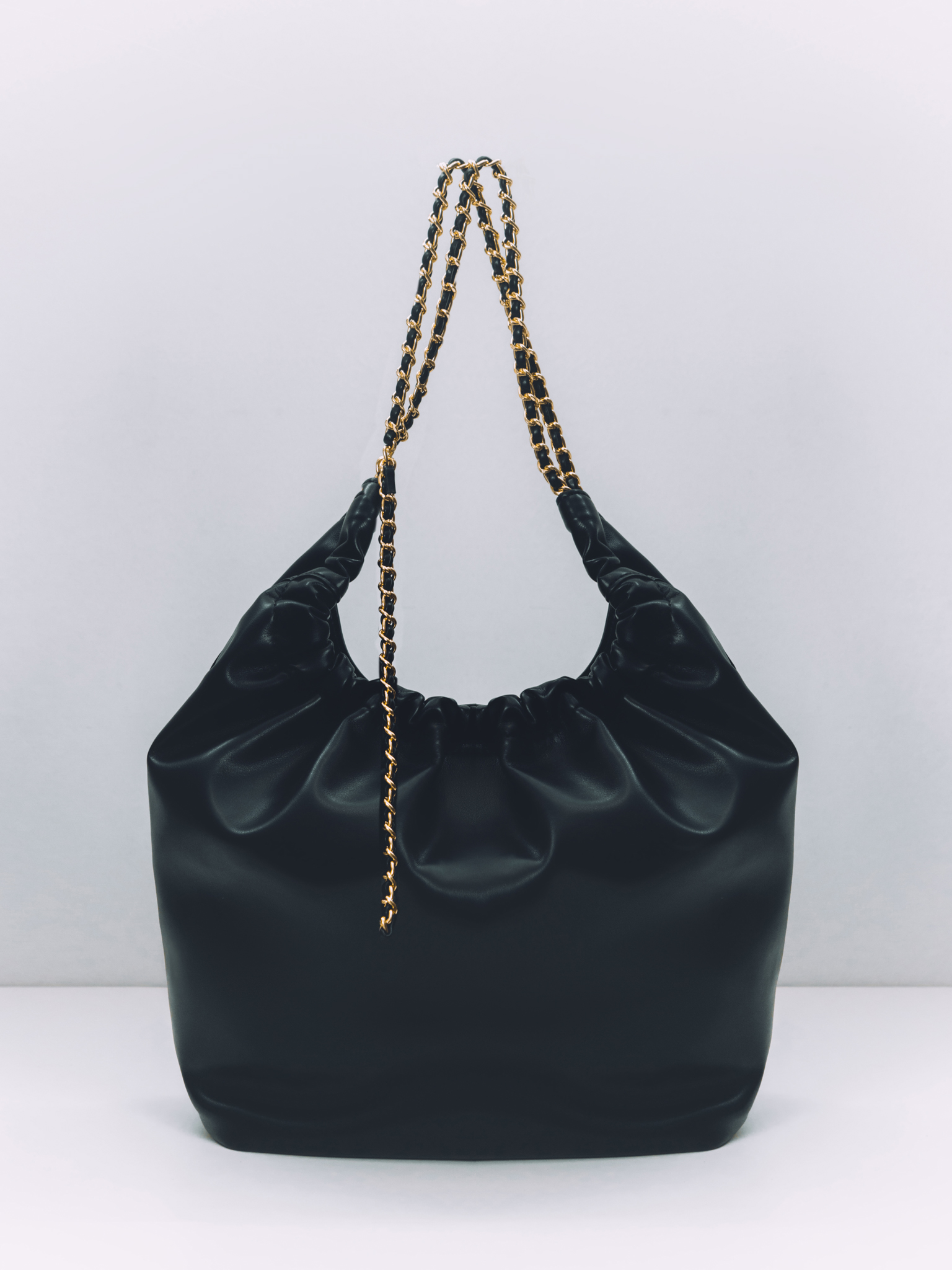 Soft-shaped bag with chain decor on the handles