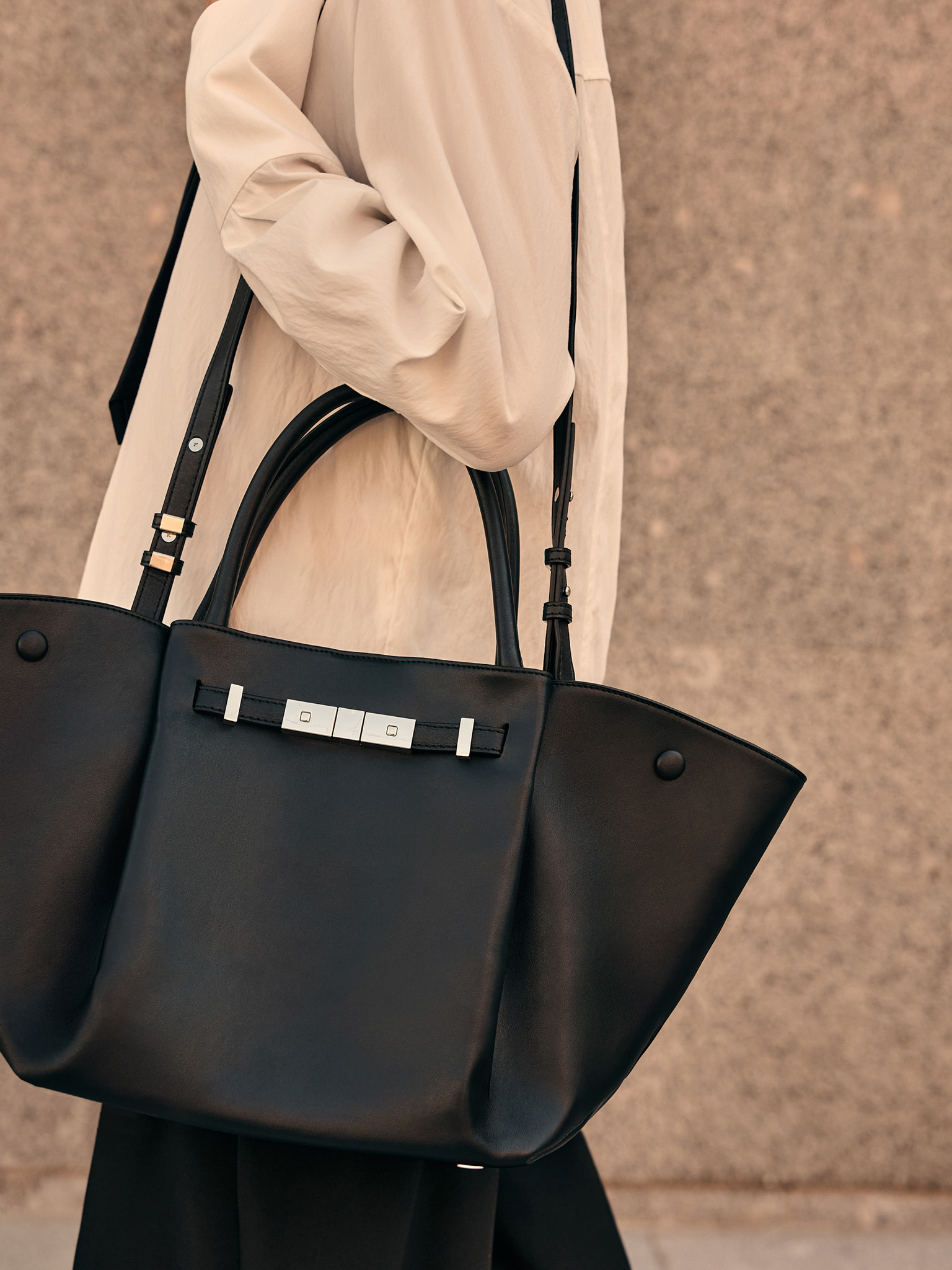 Trapezoidal bag with clasp closure