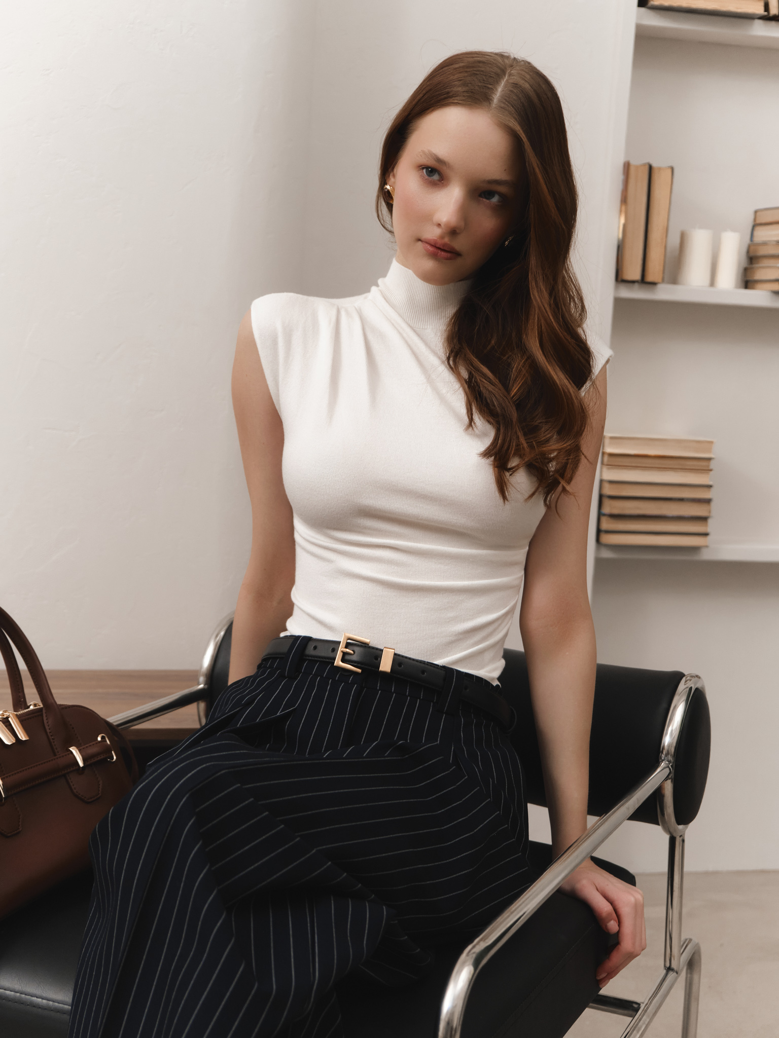 Sleeveless knitted top with pleats at the shoulder