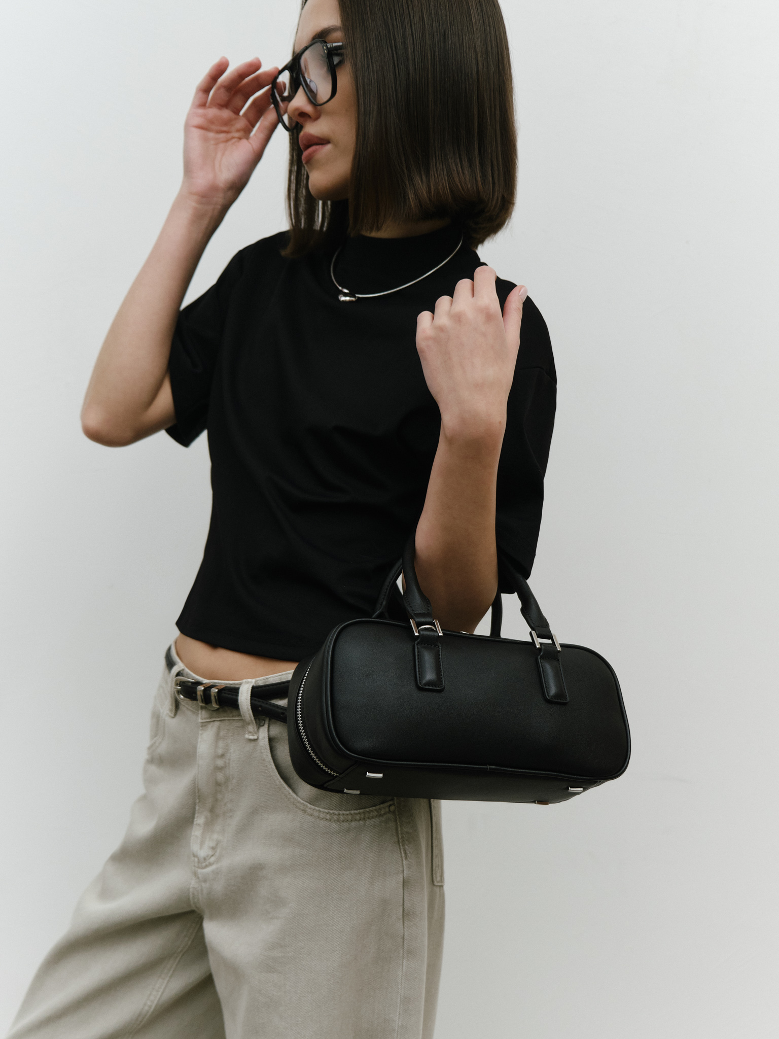 Rigid-shaped bag with short handles and a strap