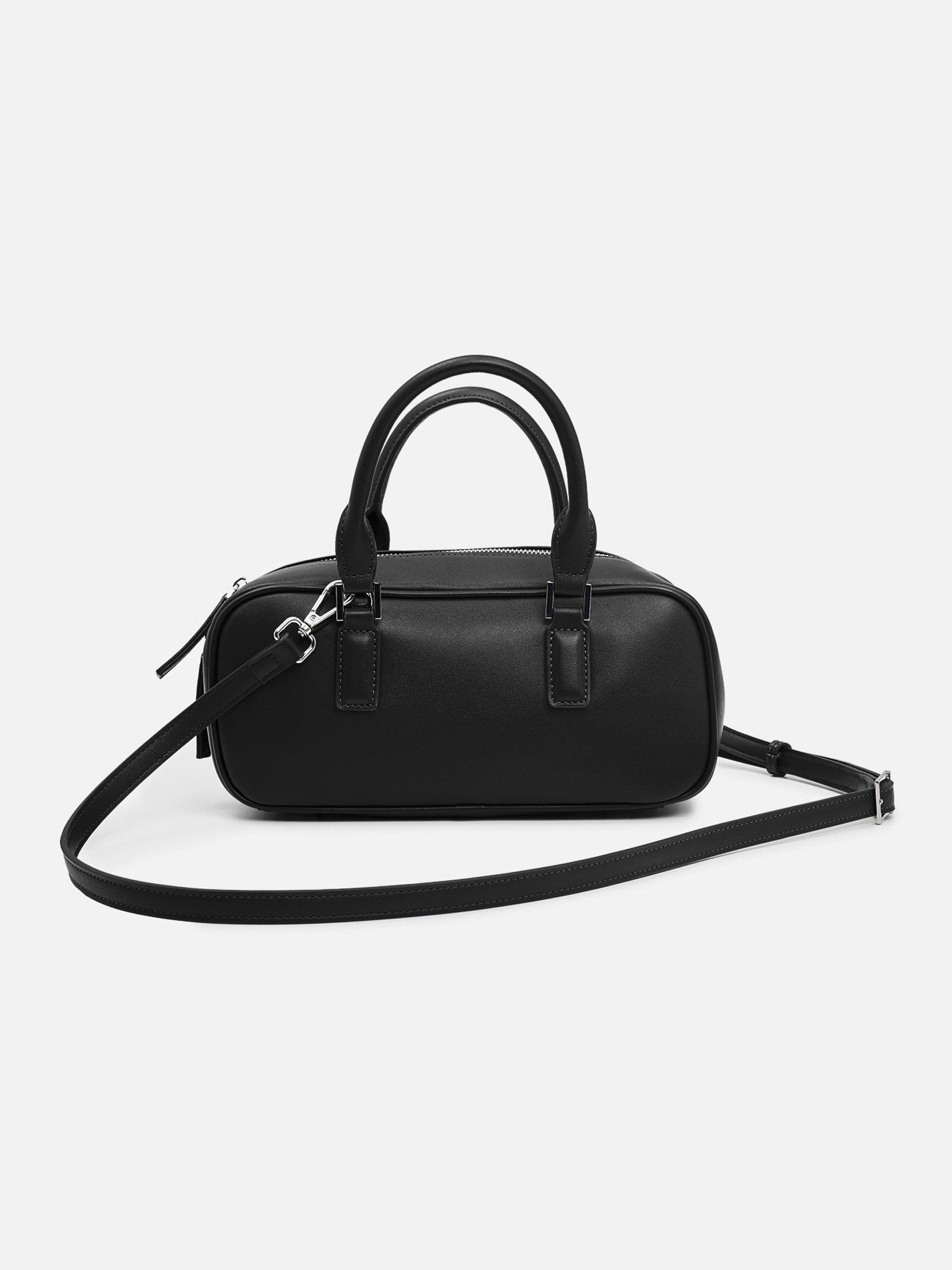 Rigid-shaped bag with short handles and a strap