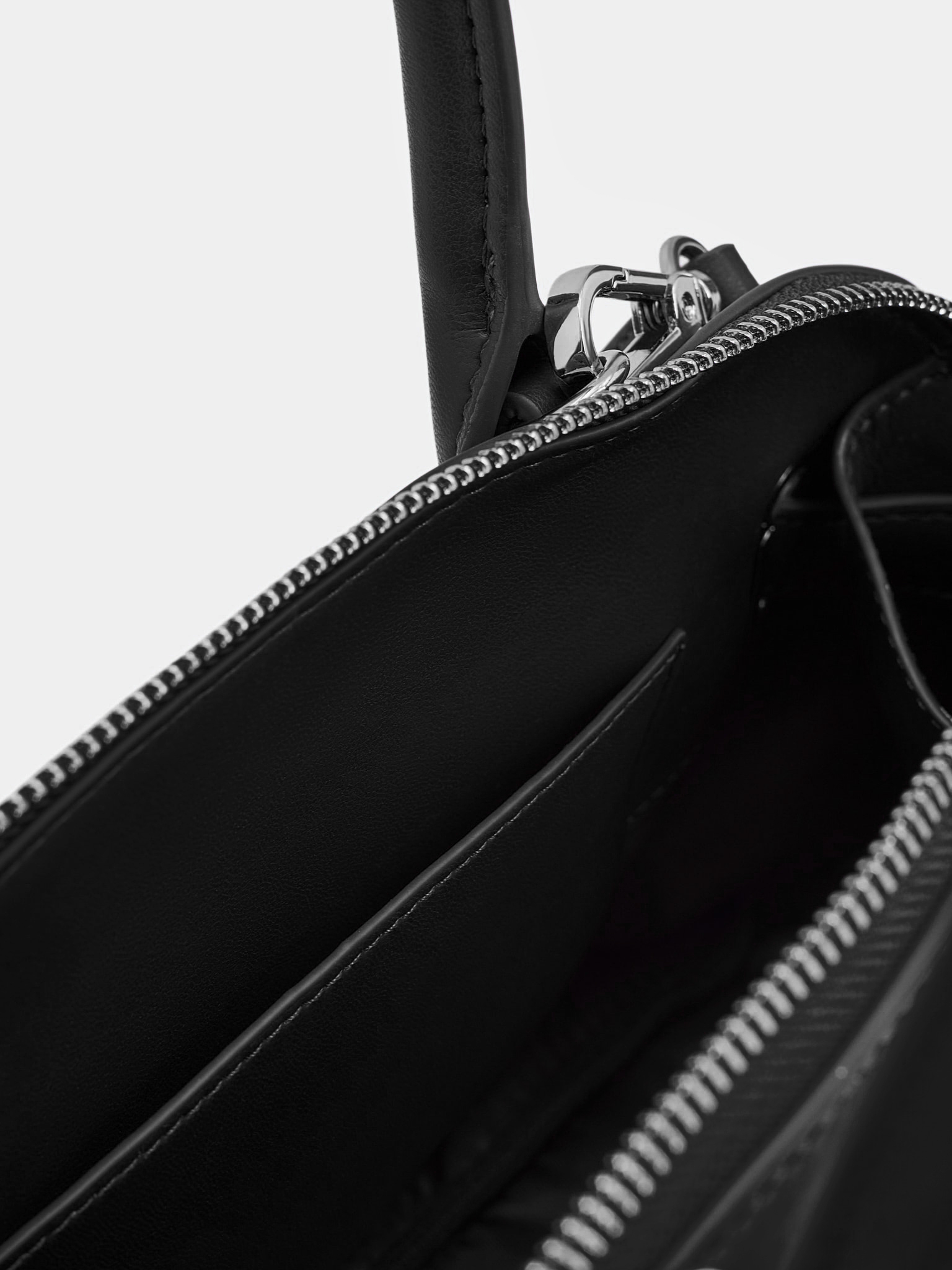 Rigid-shaped bag with short handles and a strap