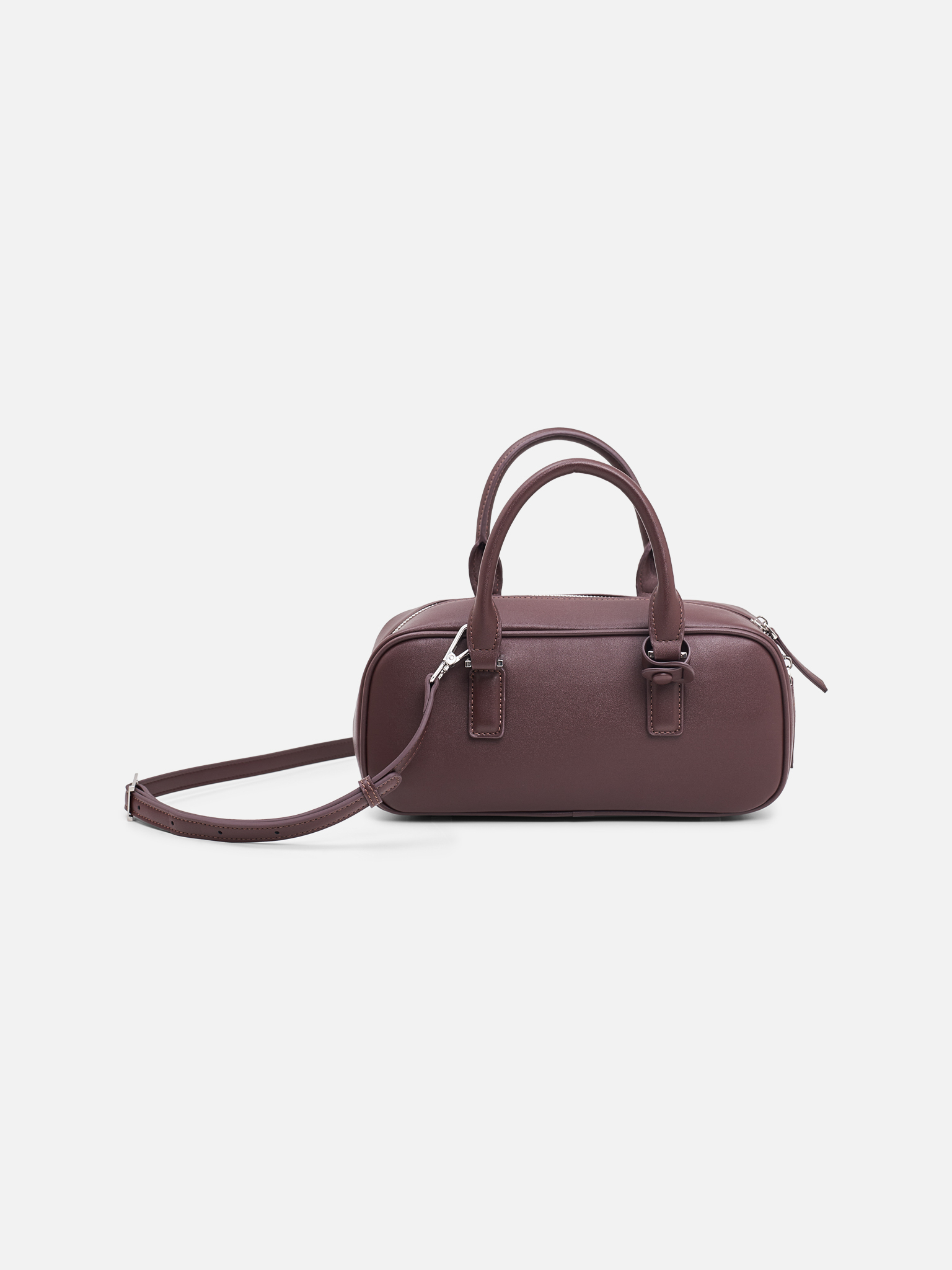 Rigid-shaped bag with short handles and a strap