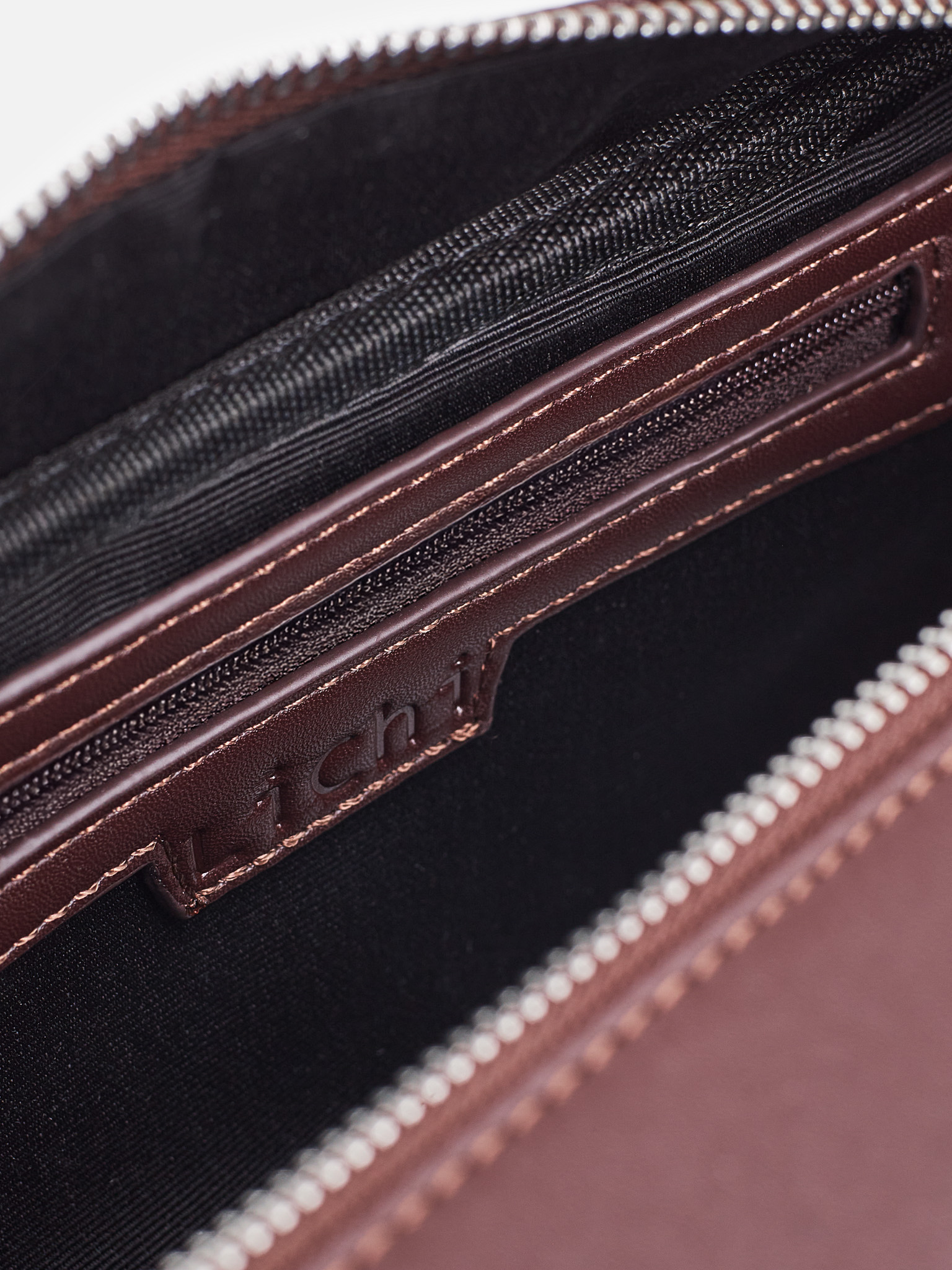 Rigid-shaped bag with short handles and a strap