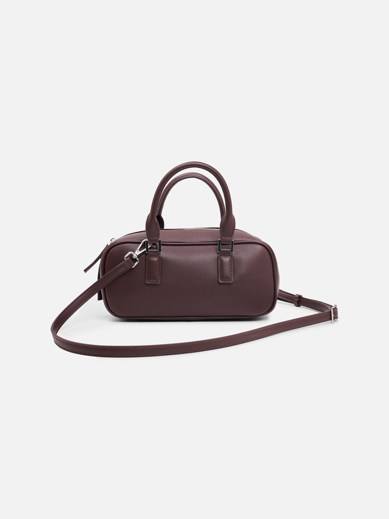 Rigid-shaped bag with short handles and a strap