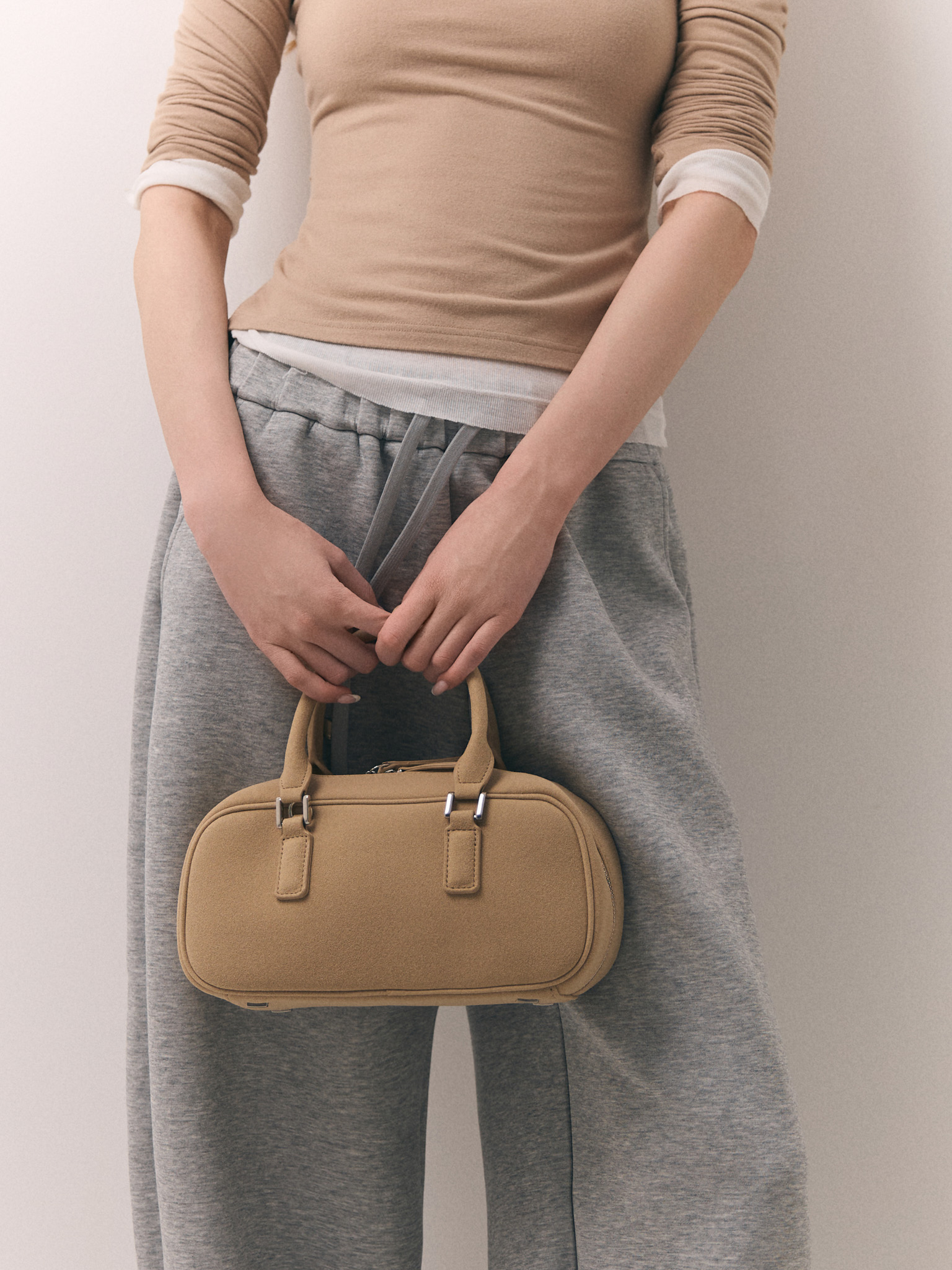 Rigid-shaped bag with short handles and a strap
