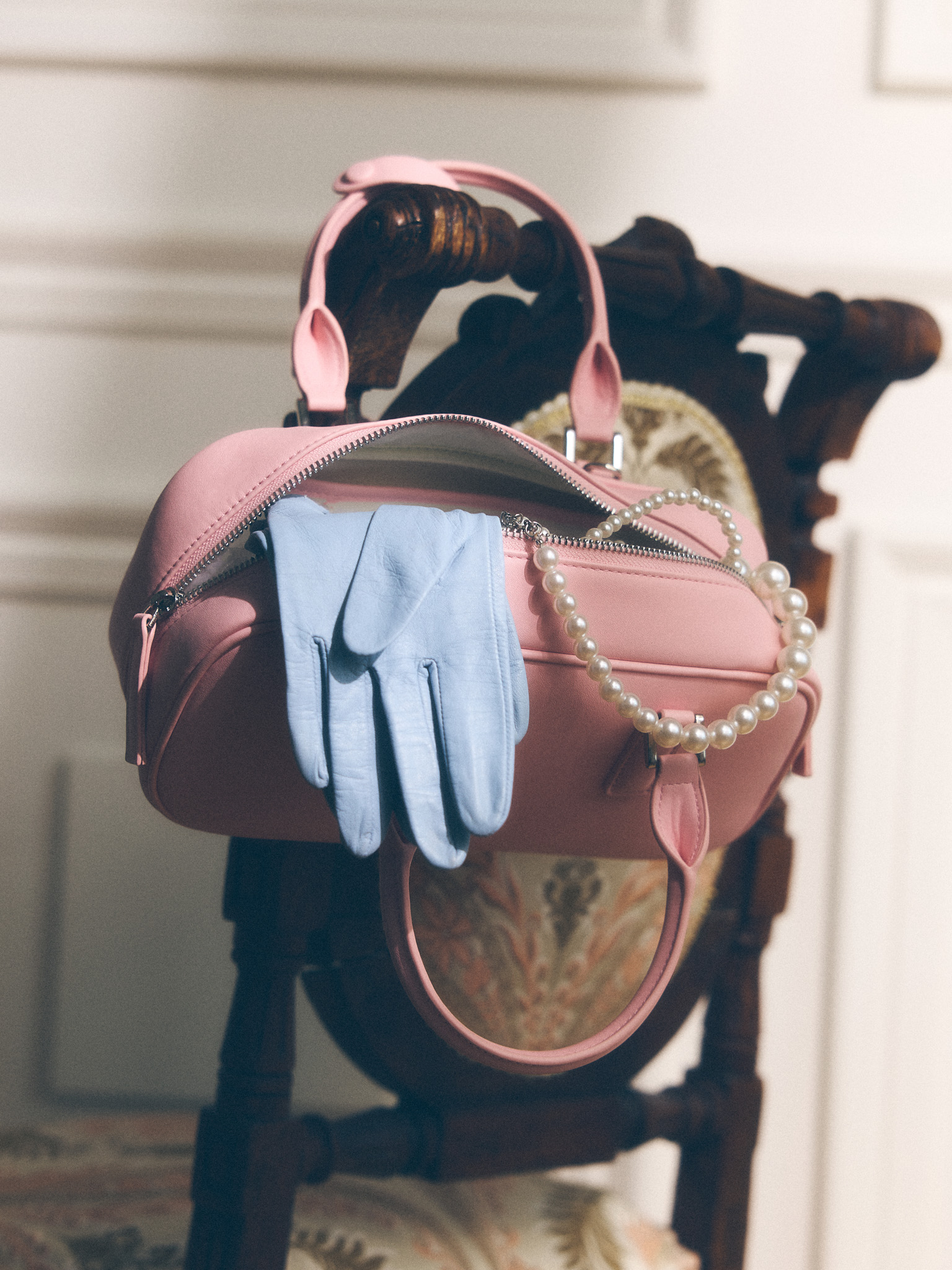 Rigid-shaped bag with short handles and a strap