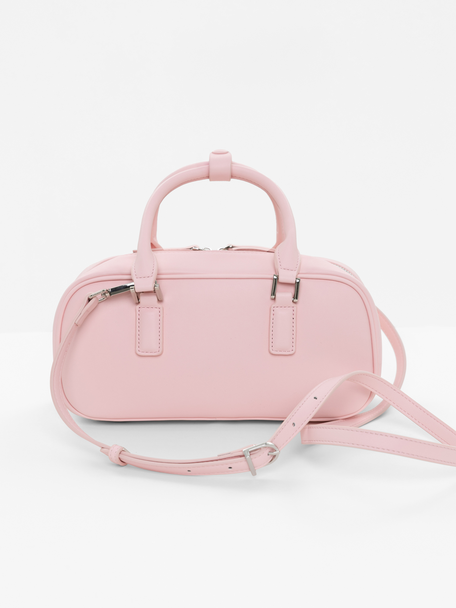 Rigid-shaped bag with short handles and a strap