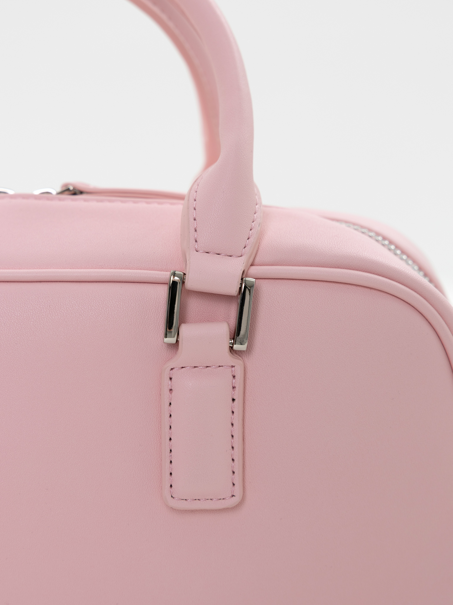 Rigid-shaped bag with short handles and a strap