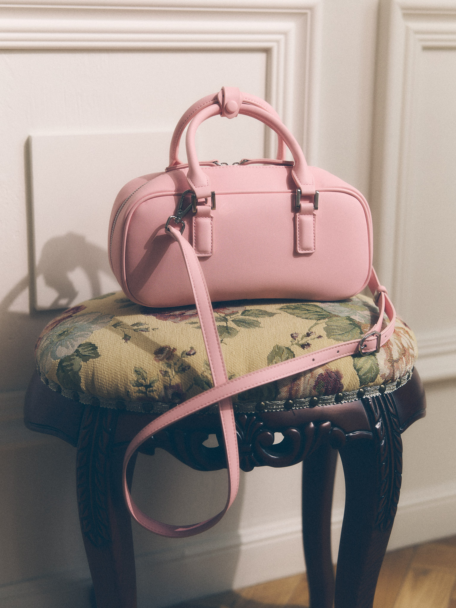 Rigid-shaped bag with short handles and a strap