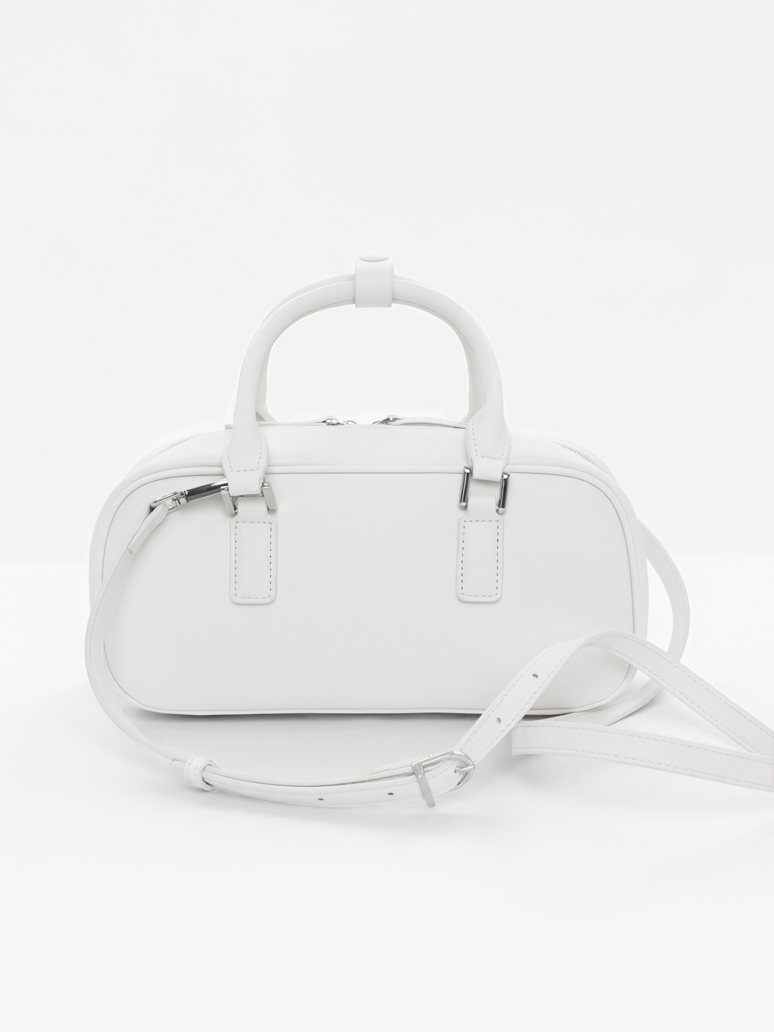 Rigid-shaped bag with short handles and a strap