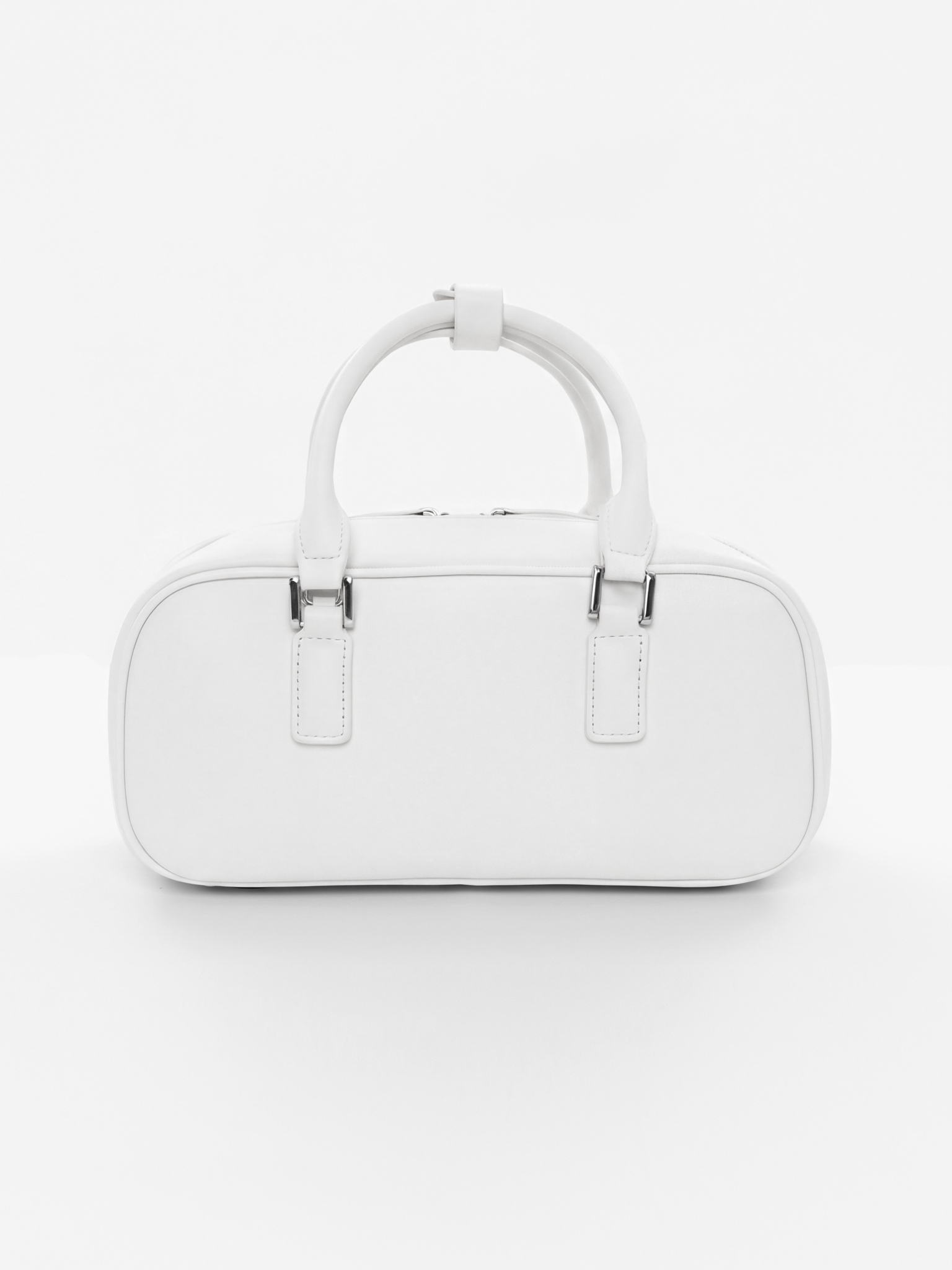 Rigid-shaped bag with short handles and a strap