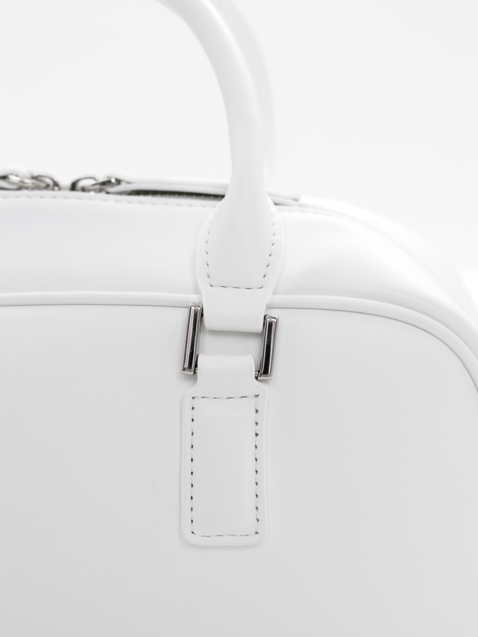 Rigid-shaped bag with short handles and a strap