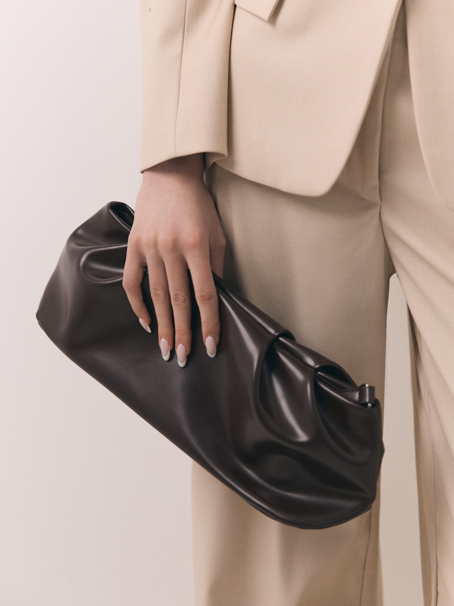 Voluminous eco-leather clutch bag with a thin strap
