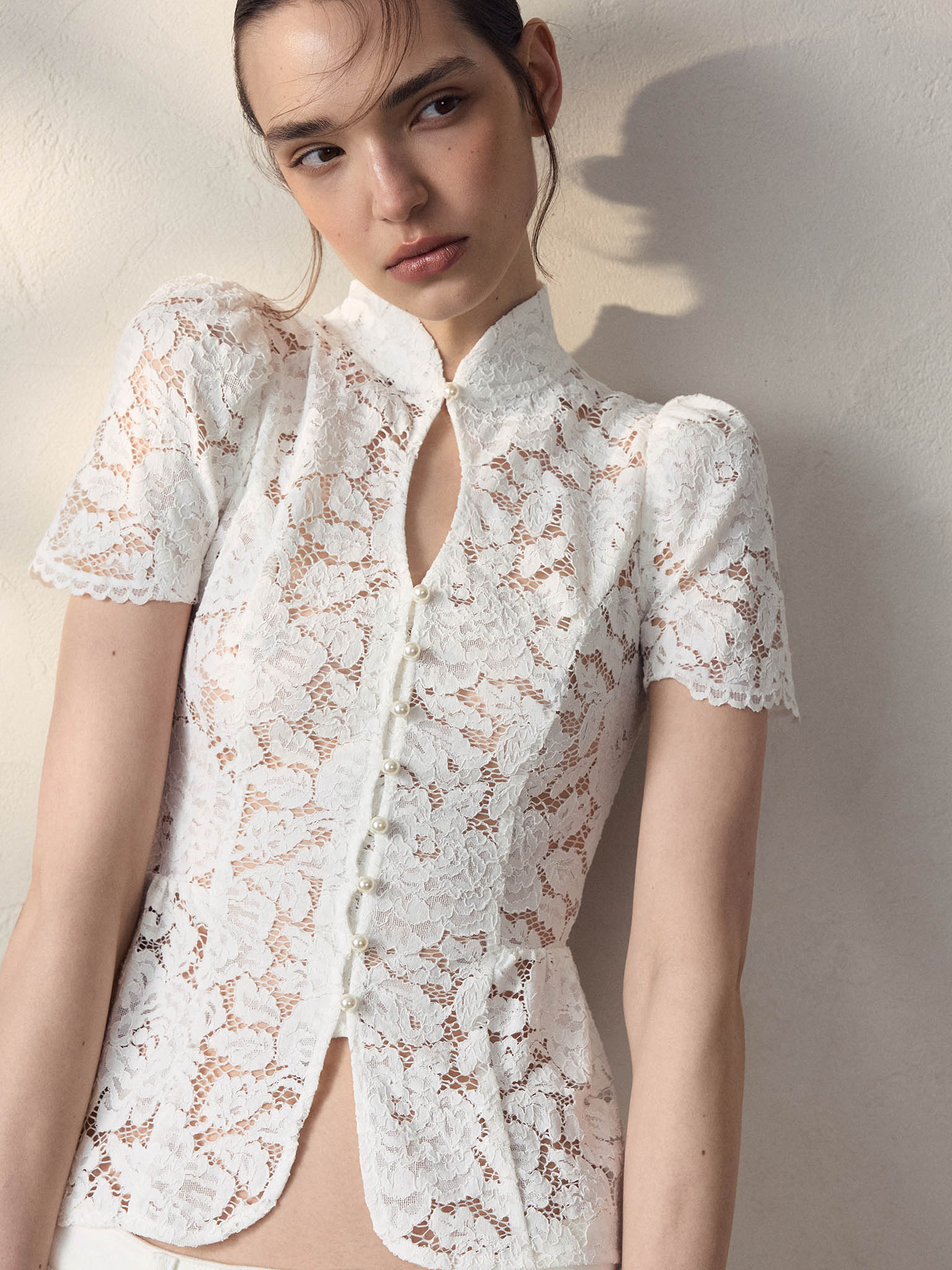 Blouse ajustée en guipure, avec encolure en goutte d'eau et basque