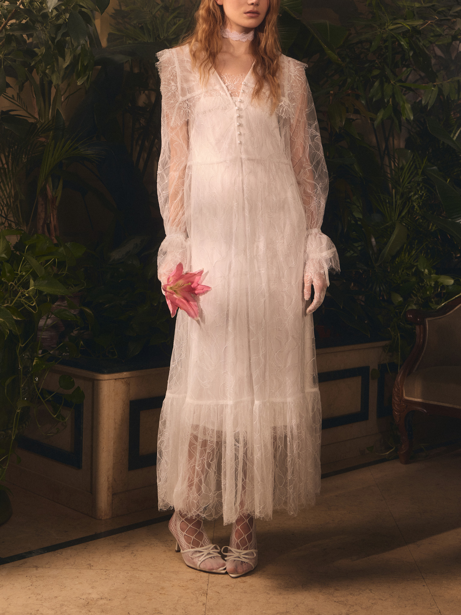 Lace cape with pearlescent button fastening